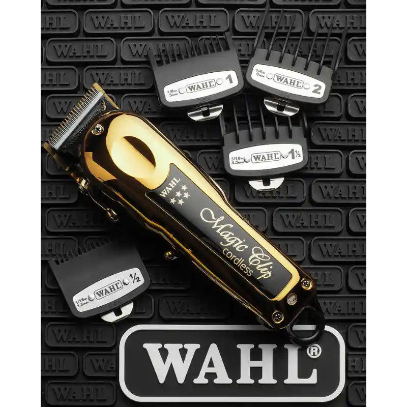 Wahl Magic Clip cordless hair clippers in a polished gold and black finish, displayed with four black guide combs and a large Wahl logo plaque on a textured black background.