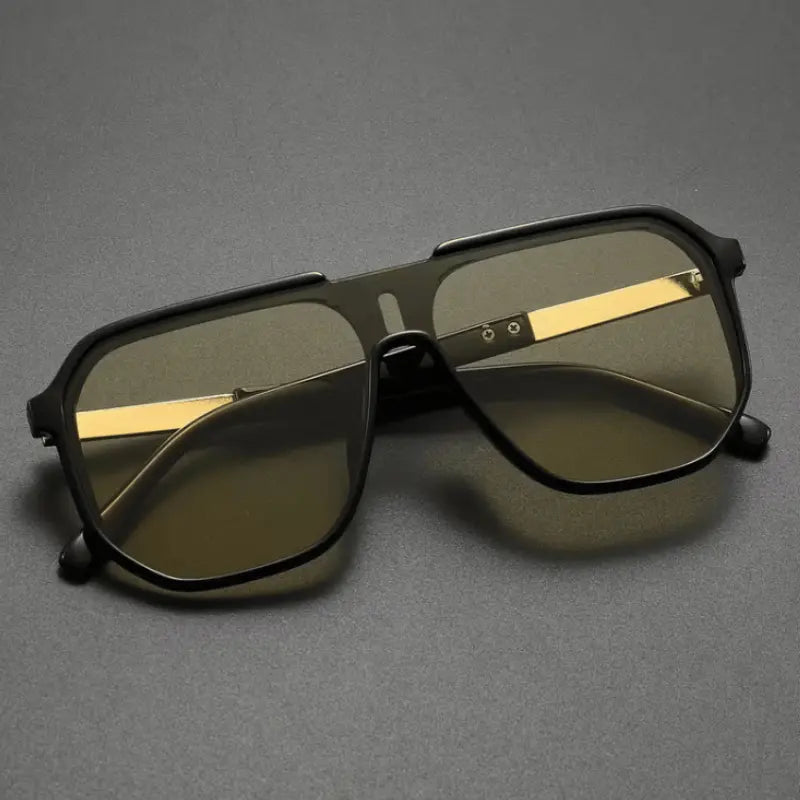 Sunglasses with gold accents on a gray background