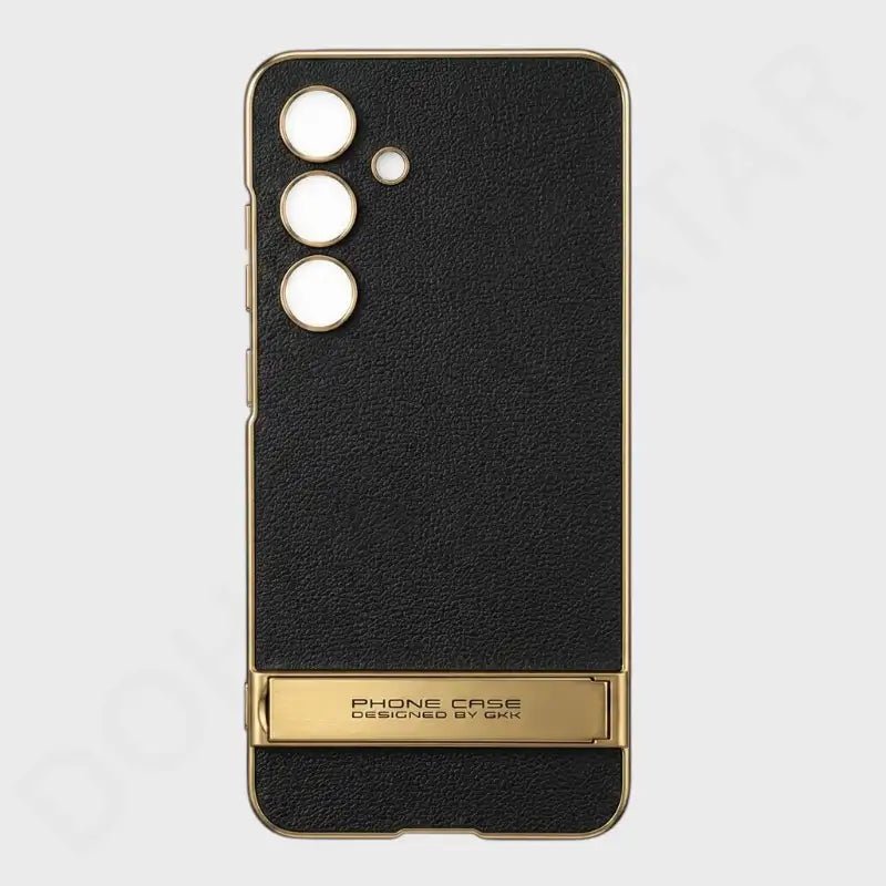 A black textured leather phone case with a gold metallic frame and a matching gold kickstand at the bottom, shown on a light gray background.