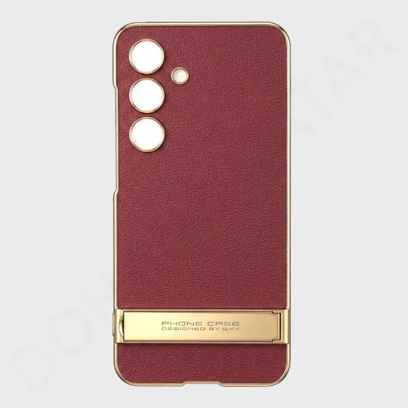 A burgundy textured phone case with a gold metal frame and a gold kickstand at the bottom, shown on a light gray background.